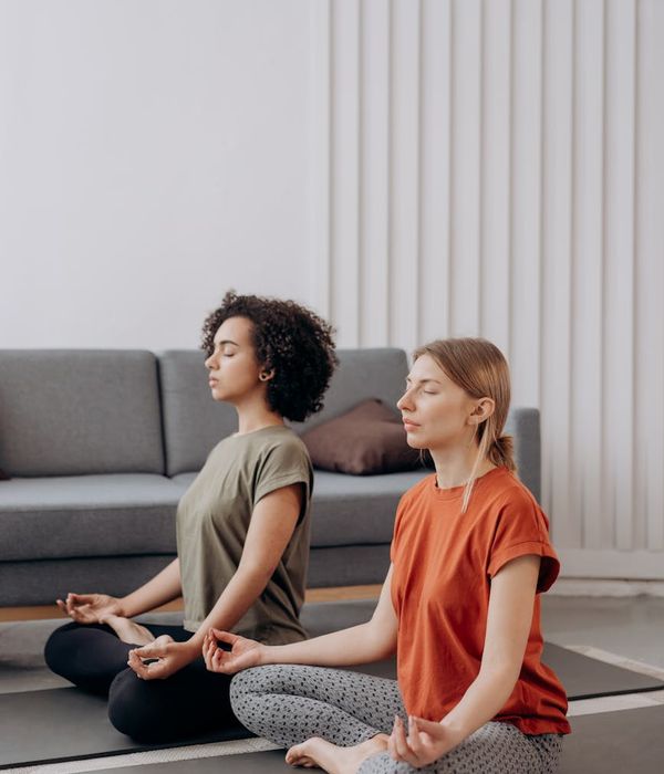 Teenager doing a peaceful yoga pose in a modern, minimalist room.
